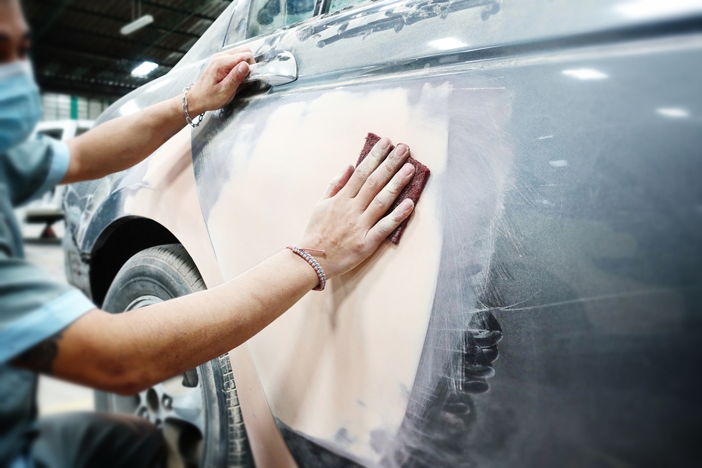 Tôlier Modelant Au Mastic La Carrosserie D'une Voiture